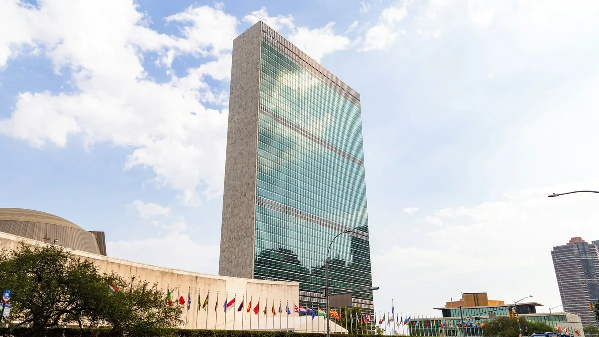 The United Nations headquarters building in New York, with flags flying.