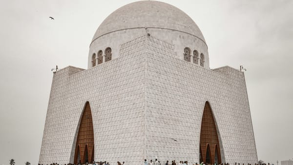 People walking near white concrete building during daytime.