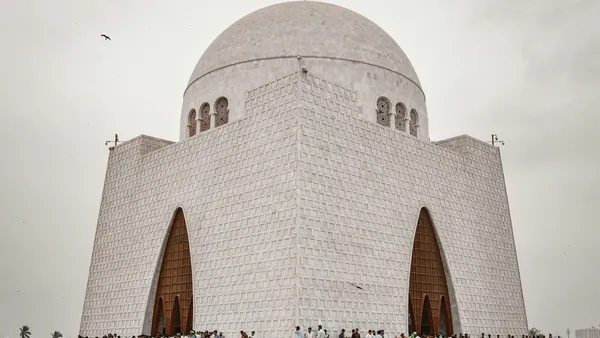 People walking near white concrete building during daytime.