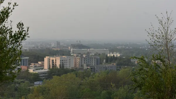 View of a city with buildings through trees.