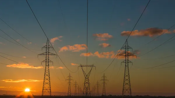 Electricity transmission towers and power lines at sunset.